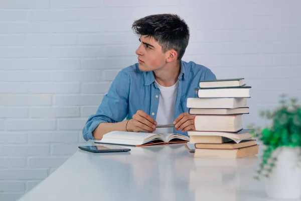 Student Thuis Aan Bureau Kijkt Zijwaarts Met Kopieerruimte — Stockfoto