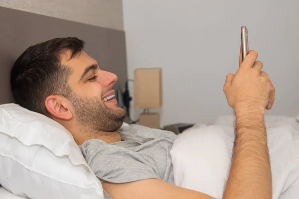 Man Bed Zoek Naar Mobiele Telefoon — Stockfoto