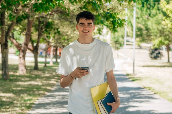 Έφηβος Φοιτητής Πόδια Βιβλία Κοιτάζοντας Κινητό Τηλέφωνο — Φωτογραφία Αρχείου