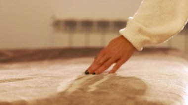 Yatağın üzerindeki yumuşaklığı okşayan el.