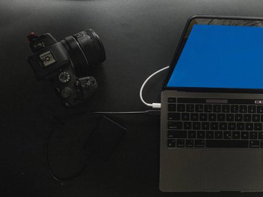 Siyah bir masada bir kamera ve dizüstü bilgisayar, yakın plan. Yüksek kalite fotoğraf