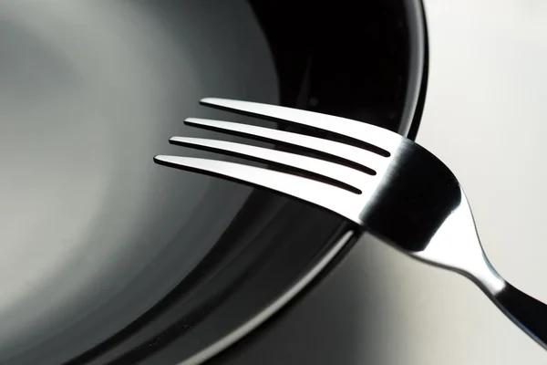 Forchette e piatto nero — Foto Stock