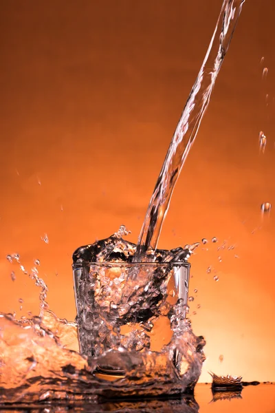 Salpicadura de agua en un vaso —  Fotos de Stock