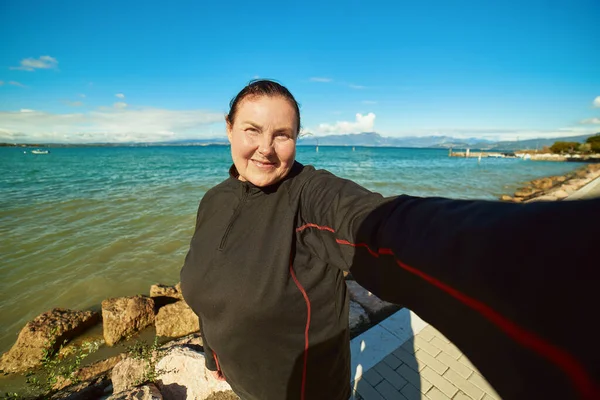 Femme âgée active faisant selfie à l'extérieur, style de vie hélicoïdal Photo De Stock