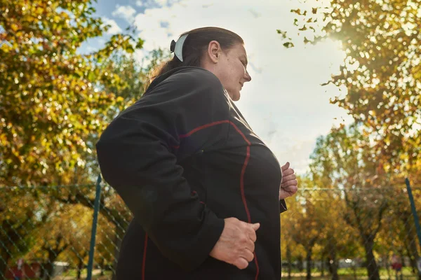 En eldre aktiv kvinne som gjør friske øvelser utendørs. Jogging – stockfoto