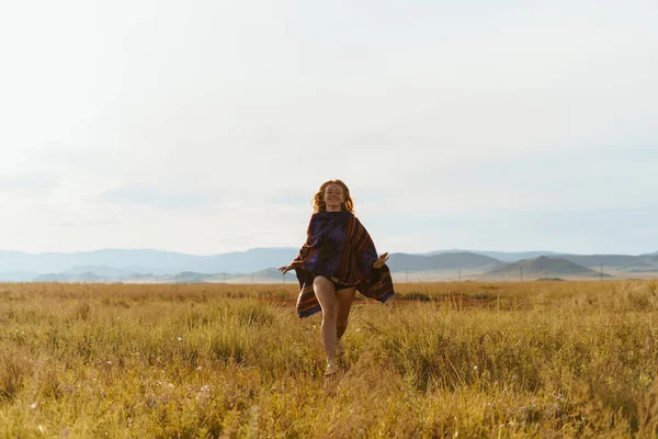 The girl runs on the field, the hair develops. Mountains and sunset. Russian Siberia — Stock Photo, Image