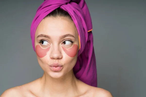 Portret pięknej dziewczyny z różowymi plamkami pod oczami i ręcznikiem na głowie, z widokiem na bok — Zdjęcie stockowe