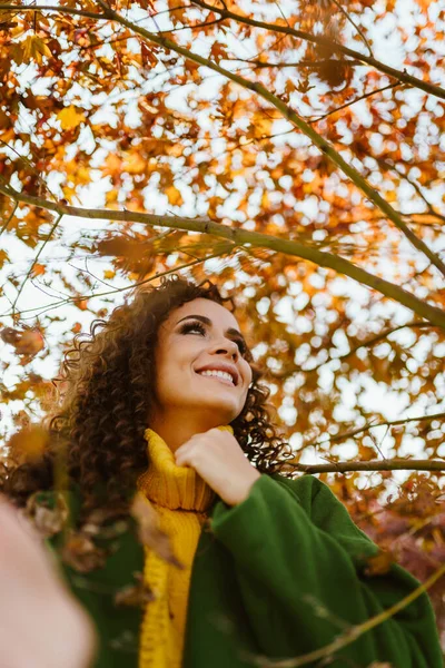 Vrolijk lachende zon kijkt in de hemel mooi brunette in de herfst park — Stockfoto