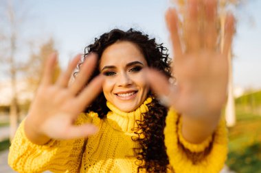 Utanç verici ve gülümseyen kız ellerini kameradan çeker.