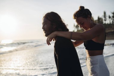 Erkekler ve kadınlar okyanusa hayrandır ve birbirlerine sevinirler.