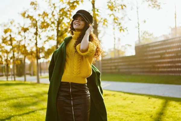 Dans le parc dans la clairière il y a une fille habillée dans le style d'un militariste et très harmonieux combinant la couleur des vêtements avec les couleurs du parc d'automne — Photo