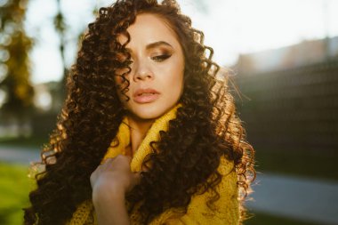 Güzel saçlı, makyajlı, güneşte dumanlı bir kız.