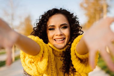 Gülümseyen kızla tanıştığıma memnun oldum. Ellerini siyah bukleli ve güzel gözlü kıza doğru çekti.