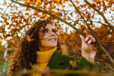 Güzel yeşil gözler ve makyaj incirleri Kıvırcık esmer gökyüzüne bakan bir gülümsemeyle