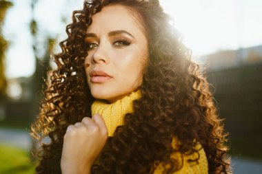 Yakın plan. Güzel, sert bir yüz ve kıvırcık bir esmer.