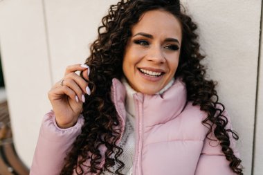 Yakın plan. Makyajlı gülümseyen dumanlı kız elini kaldırdı ve dikkat çekti.