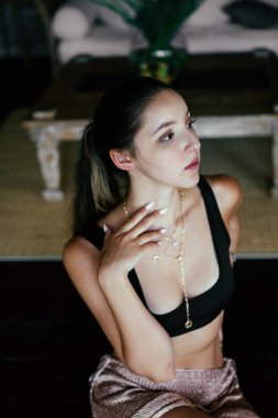 Yakın plan. Çok zarif bir şekilde elini ince yüz hatları olan bir kızın boynuna koydu.