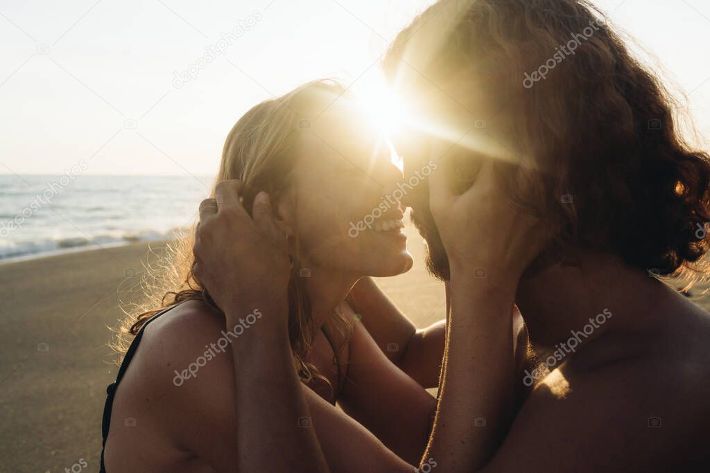 rejoices in meeting with his beloved girl hugging his head with his hands and gently rubs his nose against him in the rays of the sunset. close-up