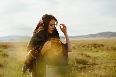 Otlakta yürür rüzgara doğru Kız çizgili bir şala sarılmış