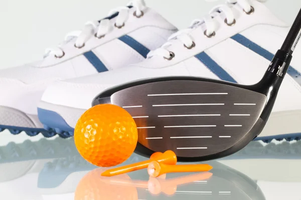 Golfschläger und Golfausrüstung auf einem Glastisch — Stockfoto