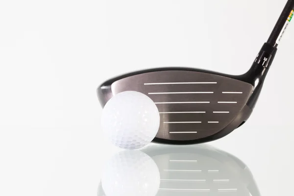 Golfschläger und weißer Ball auf einem Glastisch — Stockfoto