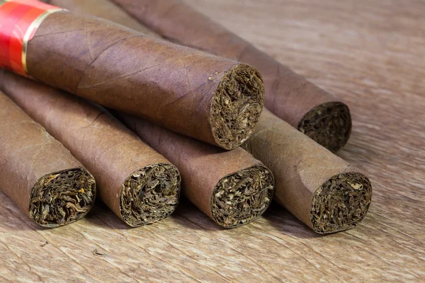 Olika cigarrer på den gamla träbord — Stockfoto