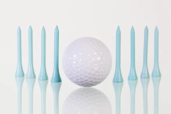 Bola de golfe e tees azuis na mesa de vidro — Fotografia de Stock