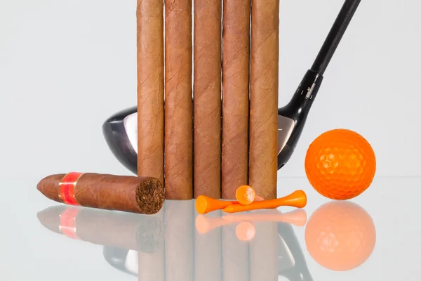 Golffahrer und verschiedene Zigarren auf einem gläsernen Schreibtisch — Stockfoto