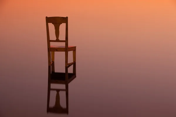 Ξύλινη καρέκλα στην επιφάνεια μιας λίμνης — Φωτογραφία Αρχείου