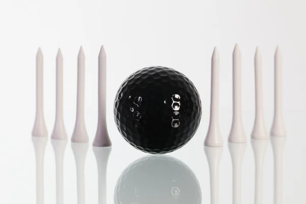 Гольф м'яч і білі трійники на скляному столі — стокове фото