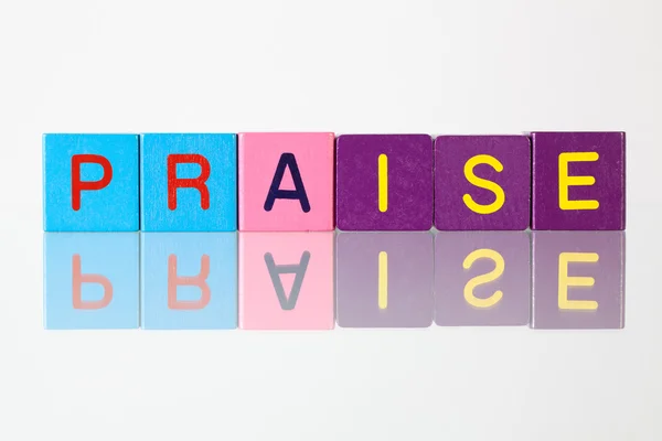 Praise - an inscription from children's blocks — Stock Photo, Image