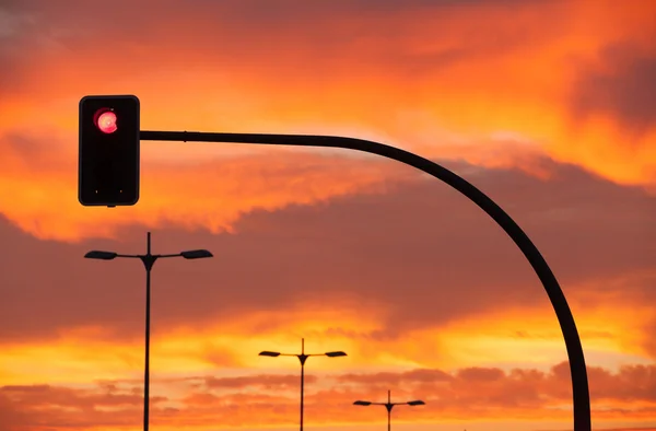 Semáforo vermelho em um pôr do sol dramático — Fotografia de Stock