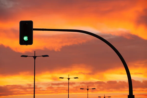 Zöld jelzőlámpa, a drámai naplemente — Stock Fotó
