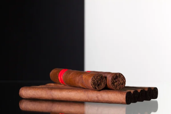 Olika cigarrer på ett glasbord — Stockfoto