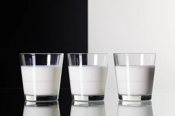 Vasos de leche aislados sobre fondo blanco y negro —  Fotos de Stock