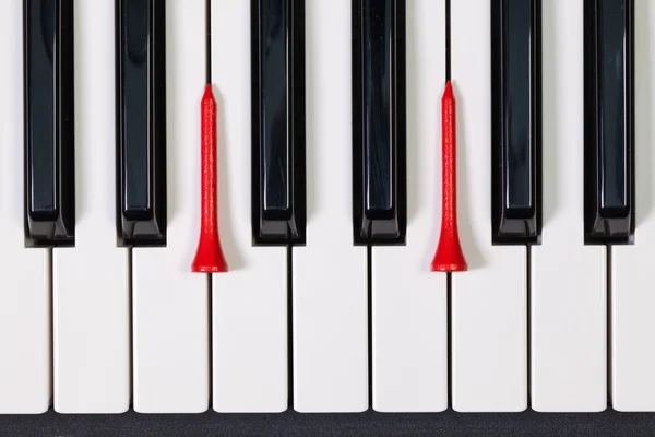 Piano keyboard och olika golfbollar och tees — Stockfoto