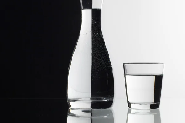 Glas vatten på svart och vit bakgrund — Stockfoto