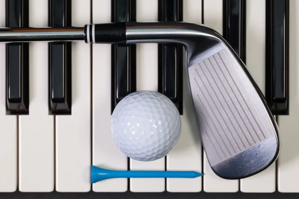 Клавиатура для фортепиано и различное оборудование для гольфа — стоковое фото