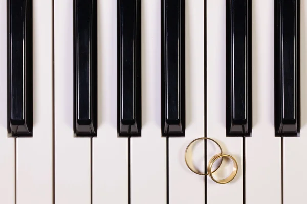 Klávesnice klavíru a snubní prsteny — Stock fotografie