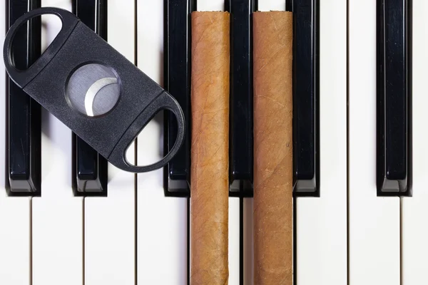 Piano keyboard och lyxiga cigarrer — Stockfoto