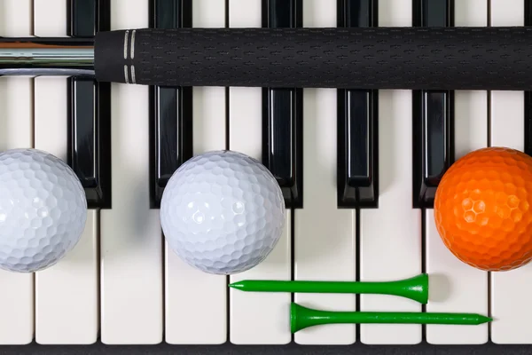 Teclado piano e diferentes equipamentos de golfe — Fotografia de Stock