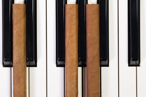 Piano keyboard och lyxiga cigarrer — Stockfoto