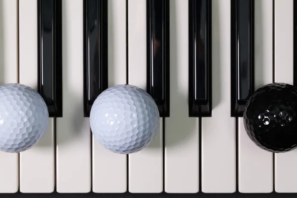 Clavier pour piano et différentes balles et tee-shirts de golf — Photo
