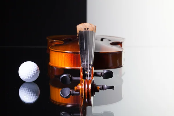 Staré housle a golfový míček na černé a bílé pozadí — Stock fotografie