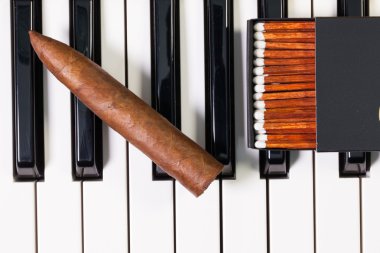 Piano keyboard and luxury cigar clipart
