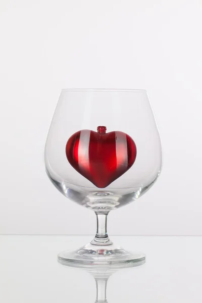 Red heart inside a glass of cognac — Stock Photo, Image