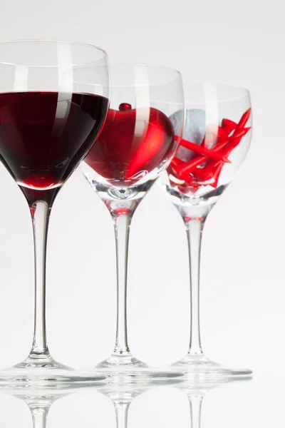 Sklenice na víno s červeným vínem, srdce a golf míček — Stock fotografie
