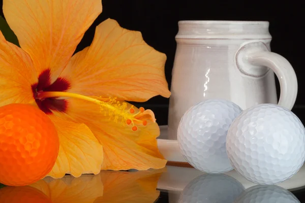 Orange hibiscus flower, cup of coffee and golf balls — Stock Photo, Image