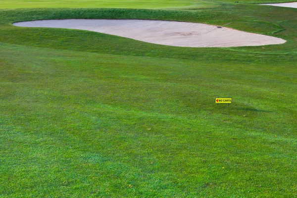 The golf bunker and a directional sign for golf carts — Stock Photo, Image