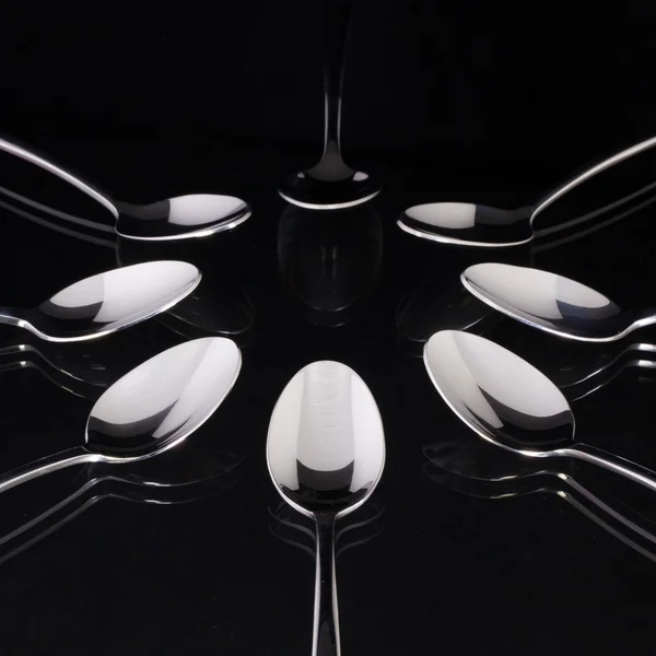 Teaspoons on the black glass table — Stock Photo, Image